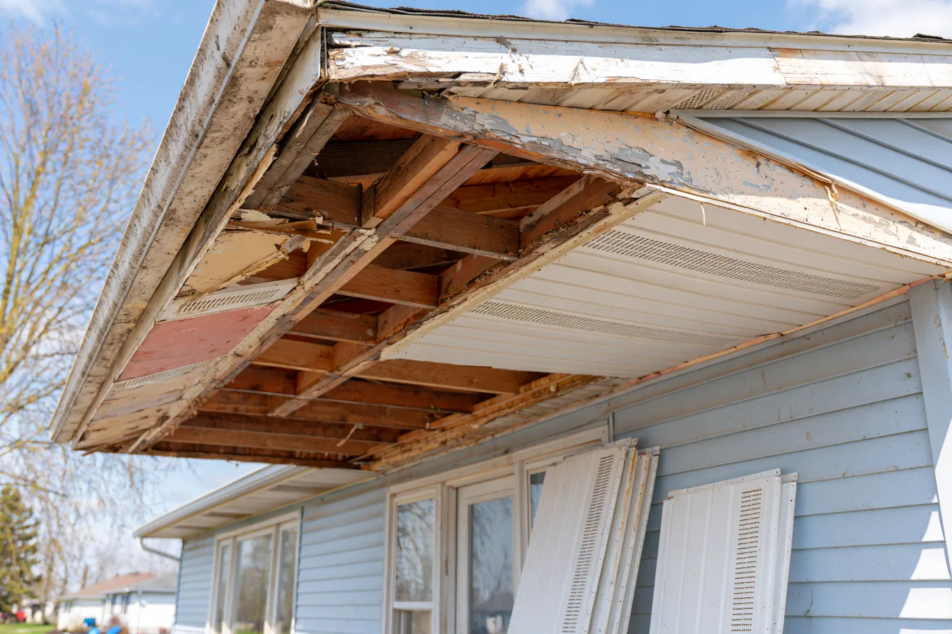 Soffit panels partly removed along an eave under repair