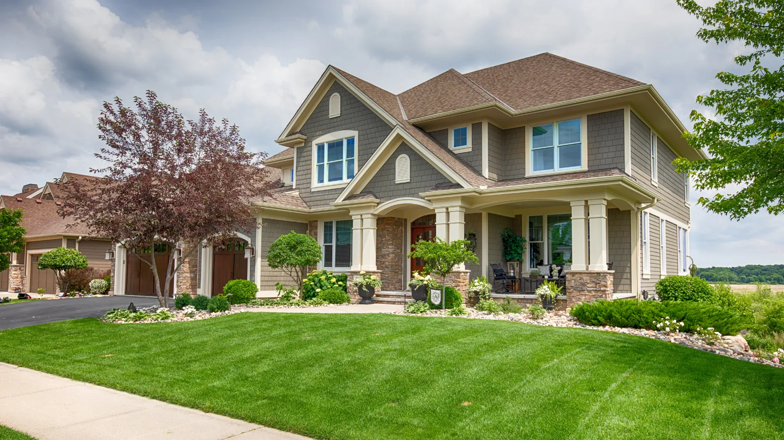 Craftsman style two-story with gray shakes and a brown hip shingle roof