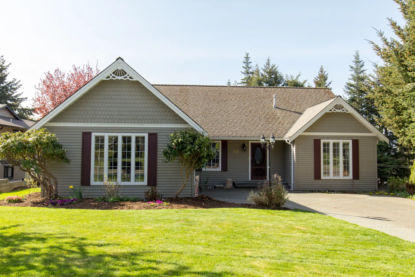 Single-story home with brown shingle roof and decorative gable trim