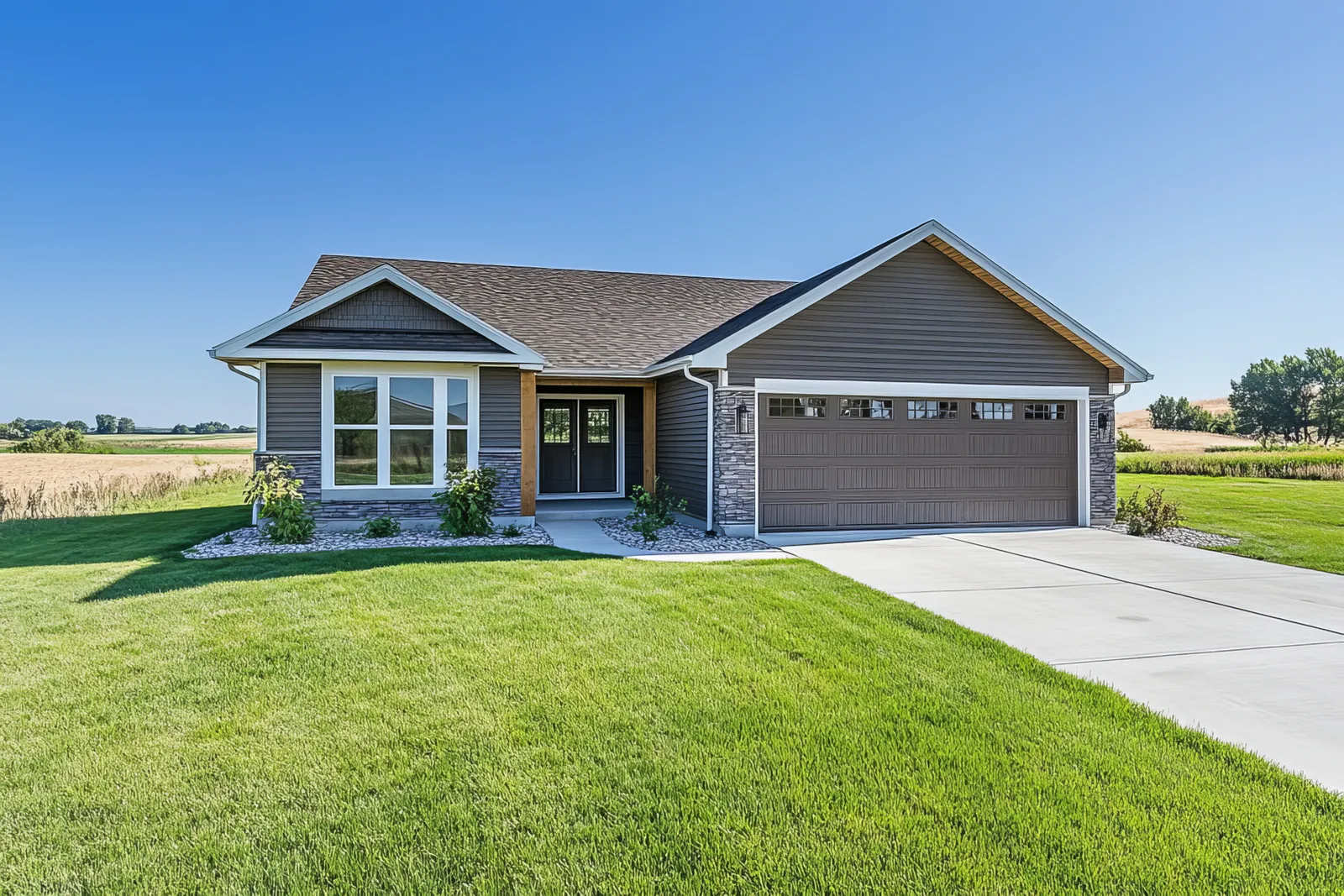 Brown shingle roof and stone accented garage on a ranch home